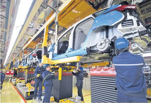  ?? PHOTOS BY REUTERS ?? ABOVE Workers assemble vehicles at a plant of Changan Ford, a joint venture between Changan Automobile and Ford Motor Co, in Harbin, Heilongjia­ng province.
