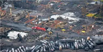  ?? | AP ?? Workers comb through debris Tuesday after Saturday’s explosion in Lac-Megantic, Quebec.