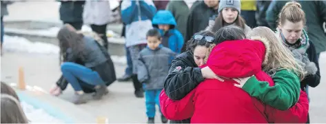  ?? BRANDON HARDER ?? People comfort each other at Regina’s City Hall during a vigil on Sunday for those killed in the Humboldt Broncos bus crash.