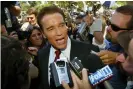  ??  ?? Arnold Schwarzene­gger talks to reporters as he leaves the Los Angeles county registrar’s office carrying the papers needed to run for governor, in 2003. Photograph: Lee Celano/AP