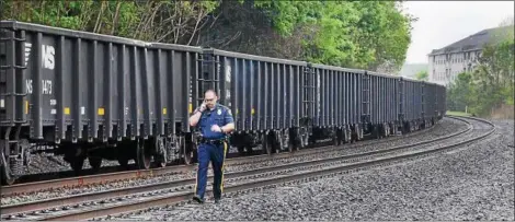  ?? TOM KELLY III — FOR DIGITAL FIRST MEDIA ?? A police officer walks past the freight train involved in Sunday morning’s fatality involving a pedestrian.