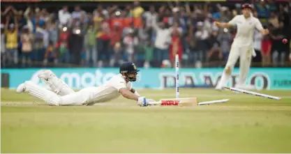  ??  ?? INDORE: India’s captain and batsman Virat Kohli reaches the wicket to avoid a runout during the first day of the third Test match between India and New Zealand at The Holkar Cricket Stadium in Indore yesterday. — AFP