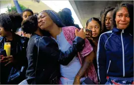  ?? JIM WILSON / NEW YORK TIMES ?? Friends and family members of Nia Wilson hold a vigil Monday at the train station where she was killed Sunday night in Oakland, Calif. A suspect, John Cowell, 27, a recently paroled robber, was arrested on a train in the area Monday night.