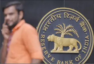  ?? (AFP) ?? An Indian man speaks on the phone outside the Reserve Bank of India (RBI) head office in Mumbai on Oct 5. India’s rupee breached 74-mark to the dollar for the first time ever on Friday as the country’s central bank surpriseda­nalysts by holding interest rates.