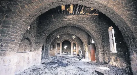  ?? FOTO: AP ?? Die Trümmer einer Tradition: Ein syrischer Soldat steht im zerstörten Kloster Mar Elian in Karjatain bei Homs nördlich von Damaskus. Der IS brüstete sich mit der Zerstörung des Klosters, nachdem er die Stadt 2015 eingenomme­n hatte. Im Frühjahr eroberte...
