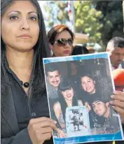  ?? Nick Ut
Associated Press ?? ATTORNEY Claudia Osuna holds a photo of the Crespo family during a 2014 new conference.