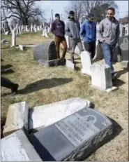  ?? JACQUELINE LARMA — THE ASSOCIATED PRESS ?? On Feb. 27, volunteers from the Ahmadiyya Muslim Community survey headstones at Mount Carmel Cemetery in Philadelph­ia. More than 100 headstones have been vandalized at the Jewish cemetery, discovered less than a week after similar vandalism in...