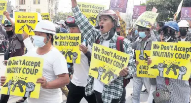  ?? AP ?? Anti-coup protesters hold signs that read, ‘We don’t accept military coup,’ during a march in Mandalay, Myanmar, on Sunday.