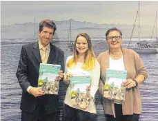  ?? FOTO: CMT ?? Frank Jost, Lena Bucher und Elisabeth Grammel zeigen das neue Gastgeberv­erzeichnis am CMT-Stand in Stuttgart.