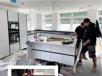  ??  ?? Below: Installing the island unit’s waterfall-effect Caesarston­e White Attica quartz. The central cut-out is for our induction hob, which will be fitted with a recirculat­ing downdraft extractor hidden underneath