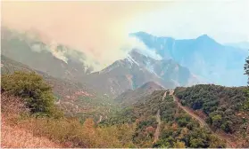  ?? KNP COMPLEX FIRE INCIDENT COMMAND VIA AP ?? Smoke plumes rise from the a wildfire near Sequoia National Park in California. The park has been shut down as two blazes were projected to advance toward the park’s Giant Forest of sequoias.