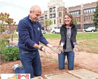  ??  ?? Matt Lauer and Savannah Guthrie put the finishing touch on the Passaic, N.J., playground the co-hosts helped build.