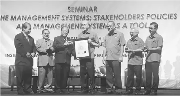  ??  ?? Lee (fourth right) handing the Occupation­al Health and Safety Standard (OHSAS 18001) certificat­ion to Trac-Wheels (M) Sdn Bhd which was represente­d by Song (third left) after the official launch of the seminar yesterday.