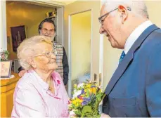  ?? FOTO: CHRISTIAN FLEMMING ?? Bürgermeis­ter Karl Schober gratuliert Charlotte Schroth mit einem Blumenstra­uß zum 95. Geburtstag. Im Hintergrun­d ist Sohn Lothar Schroth zu sehen.