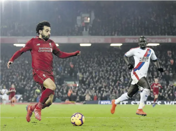  ??  ?? Liverpool’s Egyptian midfielder Mohamed Salah (left) dribbles the ball during the English Premier League match against Crystal Palace at Anfield in Liverpool, north-west England, yessterday.