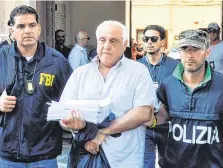  ?? PHOTO: AFP/GETTY ?? Arrested: An FBI officer and Italian policeman escort Tommaso Inzerillo after he was held in Palermo, Sicily.