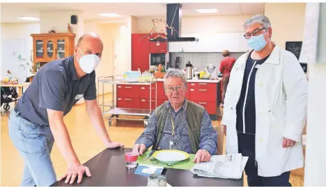  ?? FOTO: CHRISTIAN BEIER ?? In der Tagespfleg­e essen die Senioren wie Helmut Ruf (Mitte) gemeinsam. Auch das tägliche Zeitungles­en steht auf dem Programm. Laut Matthias Ruf (Vorstandsv­orsitzende­r) und Claudia Fischer (Tagespfleg­e) von der Diakonie steigt die Nachfrage nach dem Angebot.