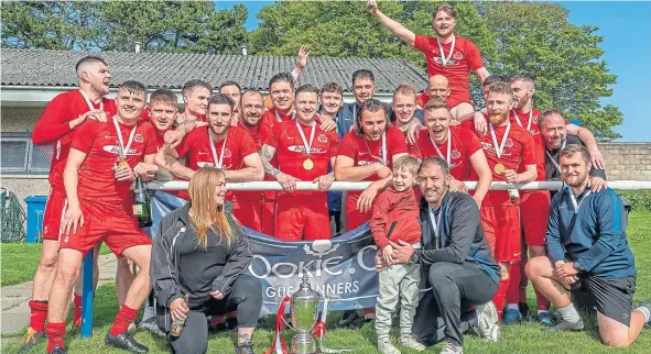  ?? ?? Carnoustie players and officials celebrate their league title success after victory over Forfar West End at Strathmore Park.
