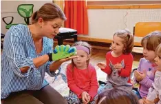  ?? Foto: Ingeborg Anderson ?? Die grüne Raupe ist das Maskottche­n des Musikinsti­tutes von Martina Brix (links). Die Kinder lauschen ganz gespannt, wenn sie erzählt.