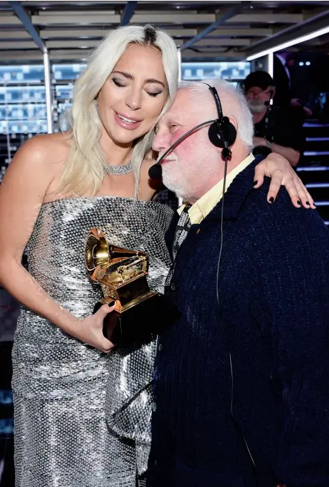  ??  ?? LIVE FOR THE APPLAUSE
Lady Gaga shares an emotional backstage moment with Ken Ehrlich after winning for pop solo performanc­e for “Joanne (Where Do You Think You’re Goin’?)” at the 61st Grammy Awards in 2019.