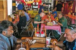  ?? ILANA PANICH-LINSMAN/NEW YORK TIMES ?? Border Patrol agents eat lunch in July at a barbecue restaurant in McAllen, Texas. One agent in El Paso said he and his colleagues had avoided eating lunch together except at certain ‘BP friendly’ restaurant­s because ‘there’s always the possibilit­y of them spitting in your food.’