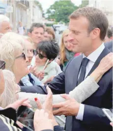  ?? — AFP ?? President Emmanuel Macron (C) speaks with people during a visit to Rochefort, western France, on Thursday.