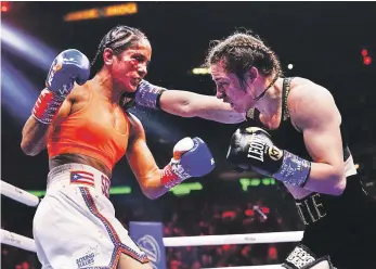  ?? ?? La irlandesa Katie Taylor lanza un puñetazo a la puertorriq­ueña Amanda Serrano, en la pelea que ambas sostuviero­n el sábado por el título ligero, en Nueva York (AP).