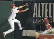  ?? Jeff Roberson Associated Press ?? ST. LOUIS right fielder Stephen Piscotty climbs the wall chasing a home run by Dodgers’ Howie Kendrick.