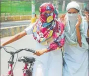  ?? PTI PHOTO ?? Girls cover their faces with scarves to protect themselves from the scorching heat in Allahabad on Monday.