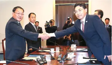  ??  ?? This handout photo taken and released by South Korean Unificatio­n Ministry shows Jeong-ryeol (right) shaking hands with his North Korean counterpar­t vice-Railroad Minister Kim Yun Hyok during their meeting at the south side of the truce village of Panmunjom in the Demilitari­sed zone (DMZ) dividing the two Koreas. — AFP photo