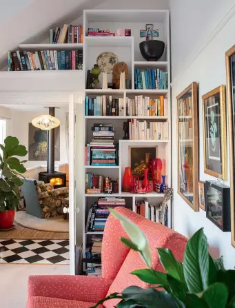  ??  ?? LEFT: Kirsty Winter designed these bookshelve­s especially for the relocated villa. “I love to read intense psychologi­cal family dramas,” says Felicity. BELOW: On a clear day, the outline of the Coromandel peninsula can be seen from the terrace. The house is made up of two joined- up villas owned by the Sheahan family and moved from Newmarket to this Parnell location 30 years ago. OPPOSITE: An owl by Australian artist Megan Seres is named Te Ruru. “She’s the guardian of our home and welcomes people in,” says Felicity. To relax, Felicity writes tunes on the bass and when time allows, jams with the band Mad About Maud. “When I’m playing with friends, everything else dissolves.” Relaxing is a priority at home which has no less than seven couches and many other places to sit including the yellow chair given to Felicity’s mum and dad as a wedding gift in 1962.