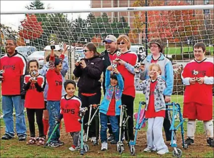  ?? PHOTO COURTESY OF SUBJECTS ?? Joe Hunter, rear center in white-blue baseball cap, stands with members of the Plymouth Township-based TOPSoccer team, part of the Civic Green Special Athletes program for kids with mental or physical challenges.