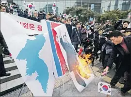  ?? Ahn Young-joon Associated Press ?? SOUTH KOREANS burn a f lag of North Korea and an image of its leader, Kim Jong Un, in Seoul to protest the North’s high-profile roles in the Winter Games.