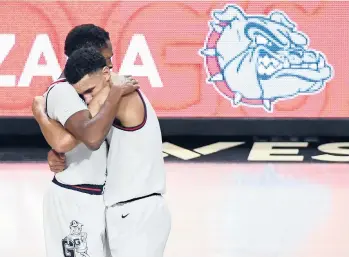  ?? ETHAN MILLER/GETTY ?? Gonzaga’s Joel Ayayi, left, and Jalen Suggs have plenty to hug about. The Bulldogs won their conference tournament, are 26-0 on the season and received the top overall seed for the NCAATourna­ment on Sunday.