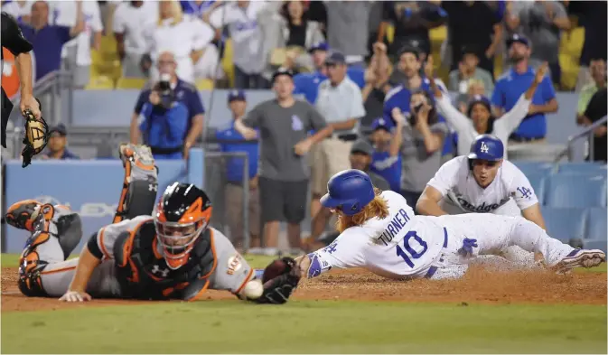  ?? —AP ?? LOS ANGELES: Los Angeles Dodgers’ Justin Turner, center, scores the winning run on a double by Kyle Farmer as San Francisco Giants catcher Buster Posey, left, reaches for an off-center throw while Corey Seager celebrates during the 11th inning of a...