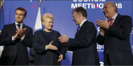  ??  ?? Lithuania’s President Dalia Grybauskai­te (center left) shakes hands with Colombia’s President Juan Manuel Santos as Organisati­on for Economic Co-operation and Developmen­t (OECD) Secretary-General Angel Gurria (right) and French President Emmanuel...