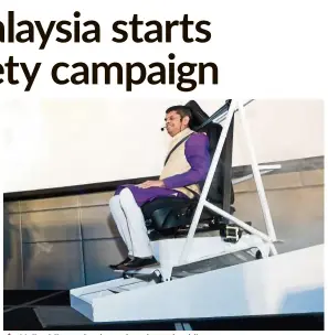  ??  ?? Nalin riding a simulator that shows buckling up can prevent a person from being thrown forward during sudden braking.