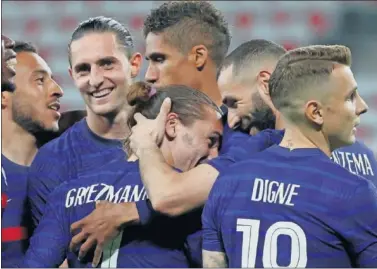  ??  ?? Griezman se abraza con Benzema y el otros compañeros tras el segundo gol de Francia.