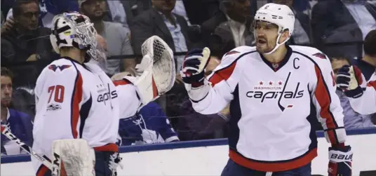  ?? RICHARD LAUTENS, TORONTO STAR ?? Washington Capitals’ Alex Ovechkin, right, celebrates his first-period goal with goalie Braden Holtby. Washington was more the team many expected as they evened the best-of-seven series 2-2.