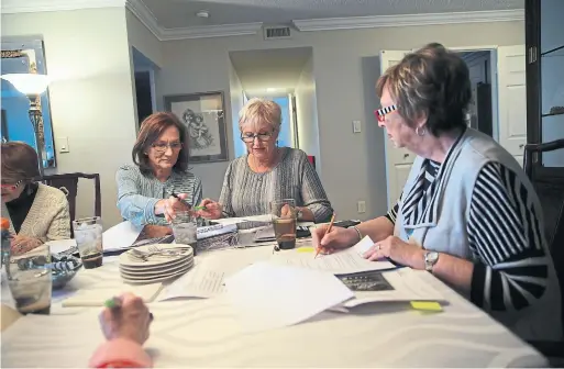  ?? RENÉ JOHNSTON TORONTO STAR ?? Donna Bryce, Sherril Colling and Debby Kaplan work on the plan for the final alumnae dinner for nursing graduates affiliated with the Women’s College Hospital.