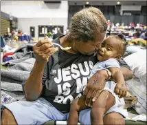  ?? JAY JANNER / AMERICAN-STATESMAN ?? Barbara Coleman feeds 10-month-old Landon Davis, a family friend who shares her home, at an emergency shelter at the Beaumont Civic Center in Beaumont after Hurricane Harvey on Aug 30. Their home in Port Arthur was flooded by the storm.