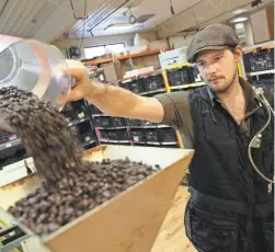  ?? USA TODAY NETWORK ?? Benjamin Lisser of Just Coffee Cooperativ­e in Madison, Wis., wears a vest that measures dangerous compounds in the air.