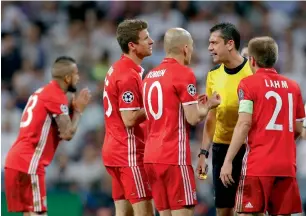  ?? AP ?? Bayern players argue with referee Viktor Kassai after he showed a second yellow card to Arturo Vidal during the Champions League quarterfin­al at Santiago Bernabeu. —