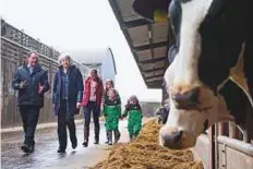  ?? AFP ?? ■ Theresa May (second left) tours a farm with its owners in Bangor, Northern Ireland yesterday.