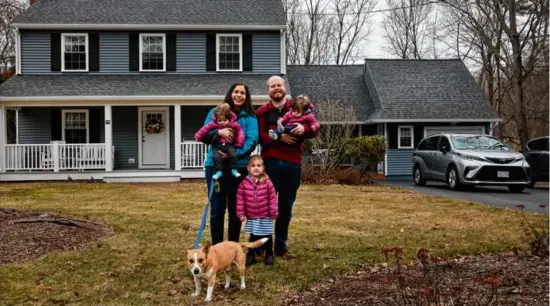  ?? CRAIG F. WALKER/GLOBE STAFF ?? Sarah and Mike McCracken pose with their 8-month-old twins, Bennett (left) and Owen (right); their daughter, Charlotte, 2; and dog, Apollo, at their home in Walpole. Sarah said that the house could have handled four people comfortabl­y, but the fact that she had twins made it seem small very quickly.