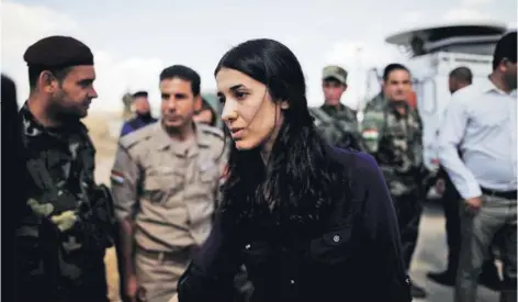  ??  ?? ► Nadia Murad saluda a los combatient­es kurdos de Peshmerga en un punto defensivo cerca de Sinjar, en 2017.