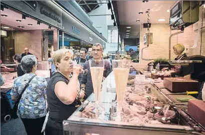  ?? ANA JIMÉNEZ ?? Los comerciant­es invitaron ayer a los clientes del mercado a una copa de cava