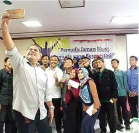  ?? UMAR WIRAHADI/JAWA POS ?? INSPIRATIF: Moh. Qosim (tengah) wefie bersama peserta para pemuda berprestas­i setelah talk show yang digelar Yayasan Pemuda Juara kemarin.