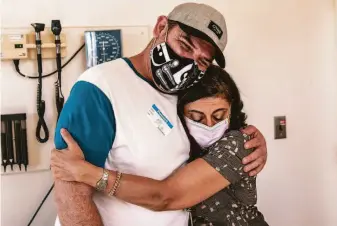  ?? Photos by Stephen Lam / The Chronicle ?? Dr. Monica Gandhi embraces patient David Holman after a visit at S.F. General’s Ward 86. Gandhi, who has backed harm reduction to fight HIV, applies the same rules to the pandemic.