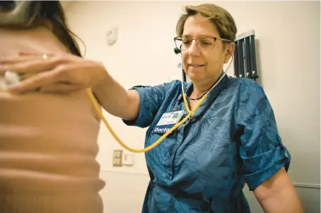  ?? ?? Dr. Marta Satin-Smith examines a diabetic patient who she’s treated for nearly 20 years at CHKD Health Center in Virginia Beach on April 7.